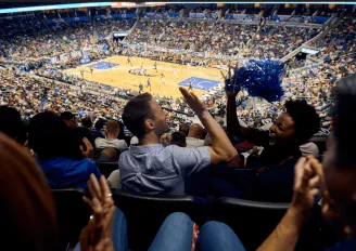 Two friends high-fiving while watching an Orlando Magic game